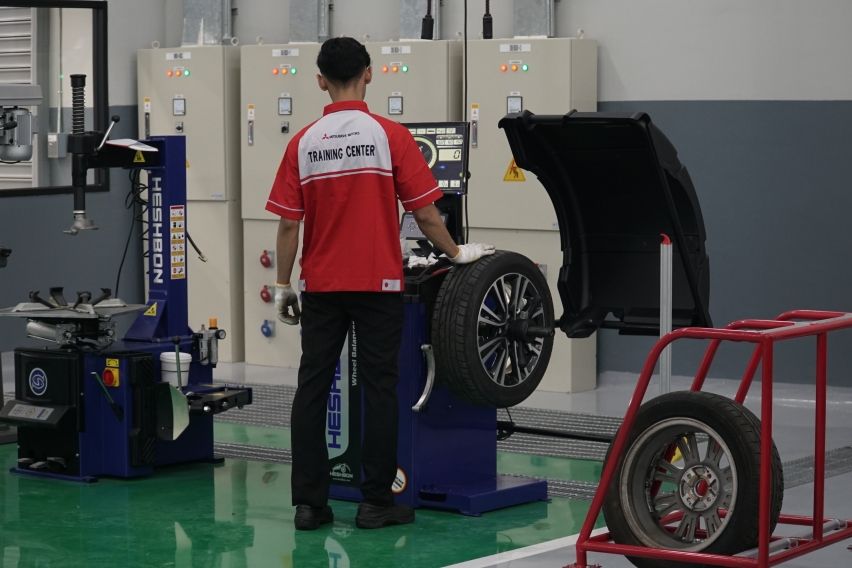 Mekanik Mitsubishi melakukan rotasi dan balancing ban mobil